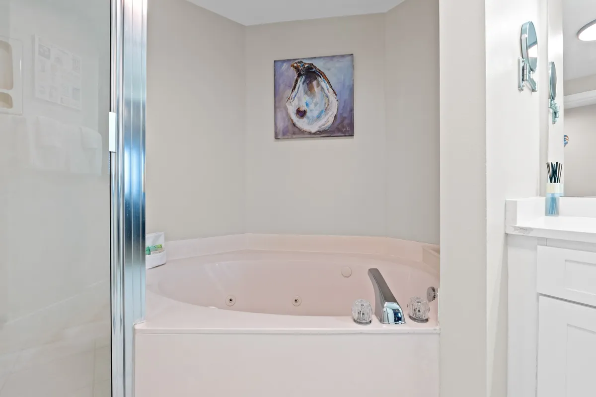 A spa-inspired bathroom featuring a luxurious jacuzzi tub, vanity area, and wall art. The atmosphere is serene and encourages relaxation and self-care, echoing the spa-like comforts described in the section.